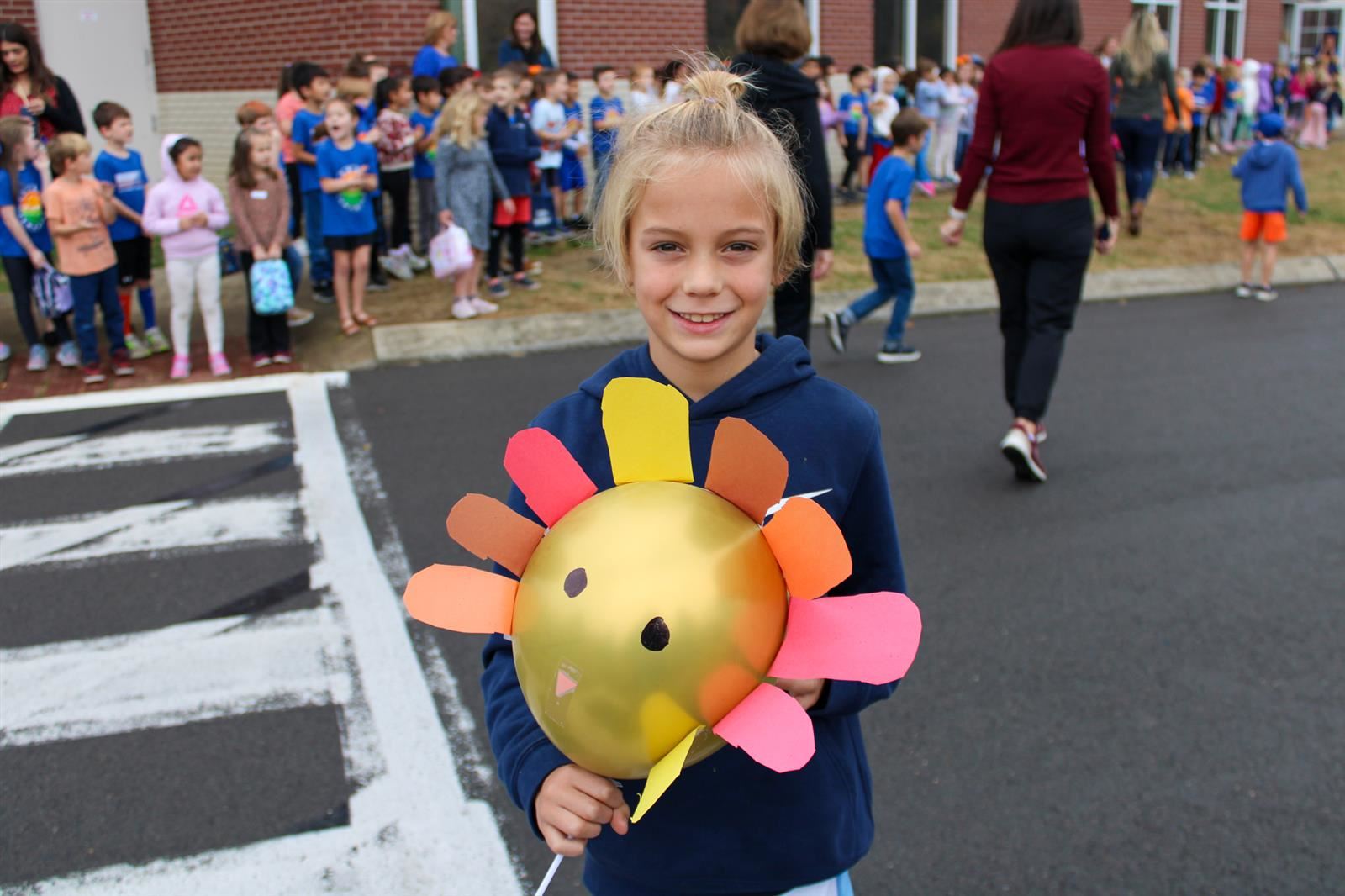 student outside with balloon turkey